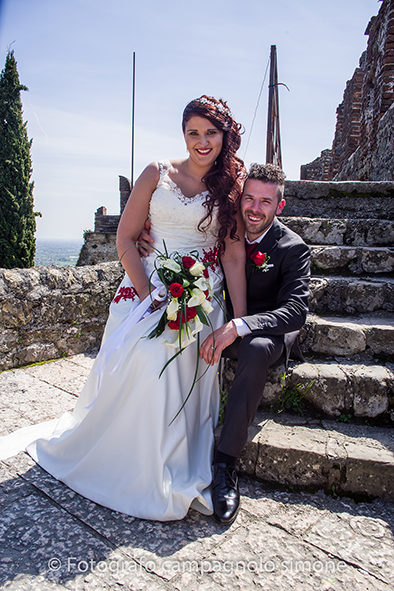 fotografo matrimonio Marostica, servizio fotografico sposi Marostica, foto nozze Marostica, album sposi Marostica, jari e lara, sposi a Marostica, gli sposi sono seduti nei gradini delle mura di Marostica e si fanno fotografare mentre si baciano.