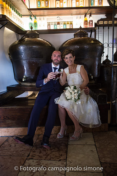 Fotografo matrimoni Rosà, fotografia matrimonio Bassano del grappa, servizio fotografico matrimoniale a Rosà e Bassano del Grappa,, fotografo sposi Rosà e Bassano del grappa, foto in verticale della distilleria Nardini con gli sposi vicino al ponte Vecchio