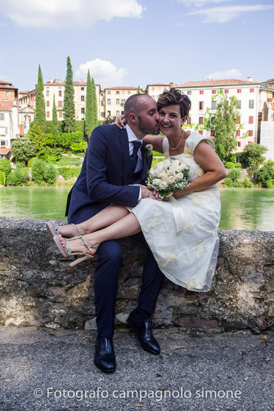 Fotografo matrimoni Rosà, fotografia matrimonio Bassano del grappa, servizio fotografico matrimoniale a Rosà e Bassano del Grappa,, fotografo sposi Rosà e Bassano del grappa, la sposa ride mentre suo marito la bacia sulla guancia.