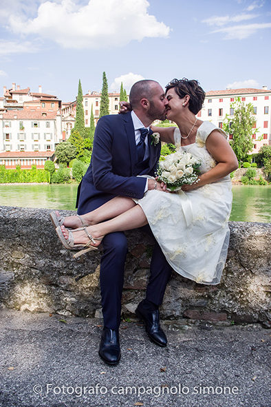 Fotografo matrimoni Rosà, fotografia matrimonio Bassano del grappa, servizio fotografico matrimoniale a Rosà e Bassano del Grappa,, fotografo sposi Rosà e Bassano del grappa, foto in verticale di sposi che si baciano seduti a Bassano del Grappa