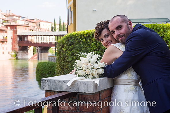 Fotografo matrimoni Rosà, fotografia matrimonio Bassano del grappa, servizio fotografico matrimoniale a Rosà e Bassano del Grappa,, fotografo sposi Rosà e Bassano del grappa, la sposa si lascia abbracciare dallo sposo mentre guardano il paesaggio di Bassano del grappa