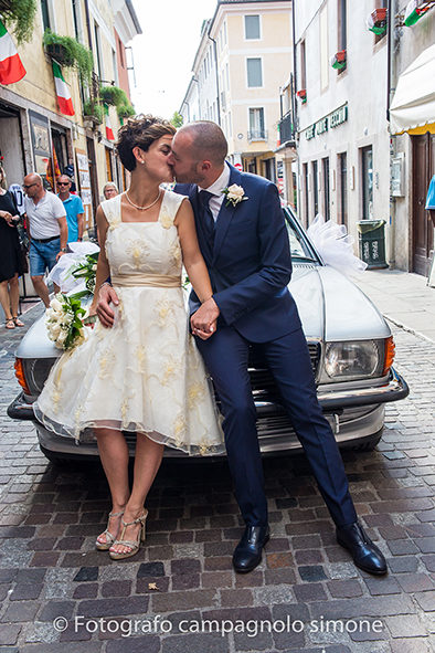 Fotografo matrimoni Rosà, fotografia matrimonio Bassano del grappa, servizio fotografico matrimoniale a Rosà e Bassano del Grappa,, fotografo sposi Rosà e Bassano del grappa, gli sposi sono seduti sopra all'auto e si baciano vicino al ponte degli alpini a Bassano.