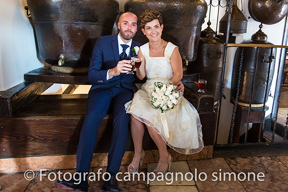 Fotografo matrimoni Rosà, fotografia matrimonio Bassano del grappa, servizio fotografico matrimoniale a Rosà e Bassano del Grappa,, fotografo sposi Rosà e Bassano del grappa, gli sposi dentro alla distilleria Nardini sono seduti nella panca