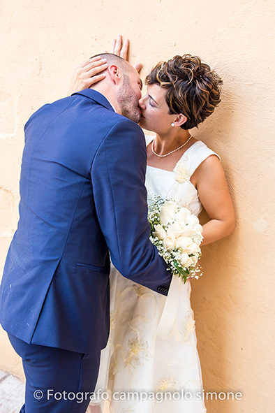 Fotografo matrimoni Rosà, fotografia matrimonio Bassano del grappa, servizio fotografico matrimoniale a Rosà e Bassano del Grappa,, fotografo sposi Rosà e Bassano del grappa, gli sposi si baciano appoggiati al miro a Bassano del Grappa