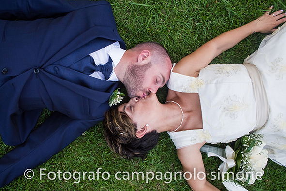 Fotografo matrimoni Rosà, fotografia matrimonio Bassano del grappa, servizio fotografico matrimoniale a Rosà e Bassano del Grappa,, fotografo sposi Rosà e Bassano del grappa, gli sposi sono sdraiati sull'erba e si baciano