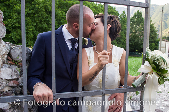 Fotografo matrimoni Rosà, fotografia matrimonio Bassano del grappa, servizio fotografico matrimoniale a Rosà e Bassano del Grappa,, fotografo sposi Rosà e Bassano del grappa, il bacio degli sposi sul cancello della chiesa a Bassano del Grappa